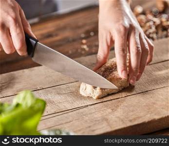 Meat with spice slice hands of cook woman on wooden kitchen board. Step by Step Cooking. A woman&rsquo;s hands are cutting meat on a wooden board on an old wooden table. Step-by-step cooking