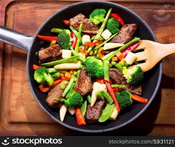 meat with vegetable in a pan on wooden board