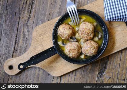 meatballs in a pan over wooden table in the kitchen