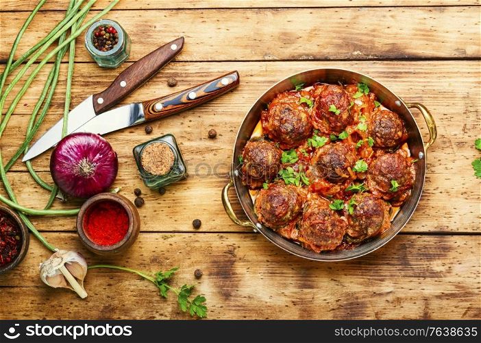 Meatballs in tomato sauce with asparagus beans on wooden table. Meat meatballs and asparagus beans