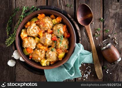 Meatballs stewed with vegetables on wooden table, top view