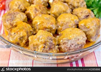 Meatballs with sauce in a glass pan on the linen tablecloth background