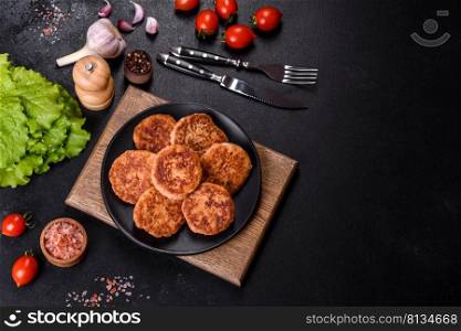 Meatballs with tomato sauce and herbs on the black plate on dark background, top view.. Meatballs with tomato sauce and herbs on the black plate