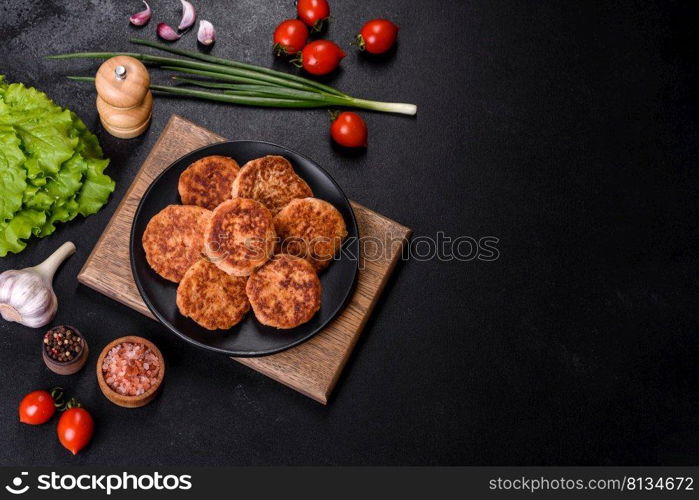 Meatballs with tomato sauce and herbs on the black plate on dark background, top view.. Meatballs with tomato sauce and herbs on the black plate