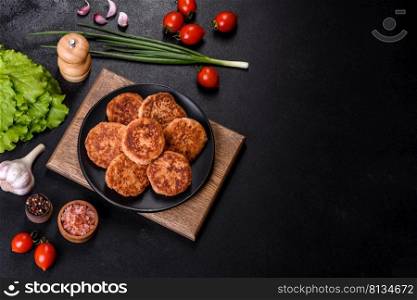 Meatballs with tomato sauce and herbs on the black plate on dark background, top view.. Meatballs with tomato sauce and herbs on the black plate