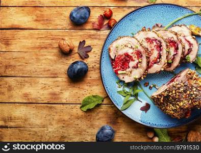 Meatloaf stuffed with plums. Autumn meat recipe, porchetta.Copy space. Juicy meatloaf with plums,space for text