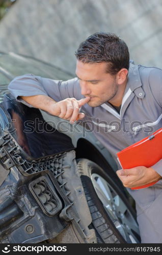 Mechanic assessing car