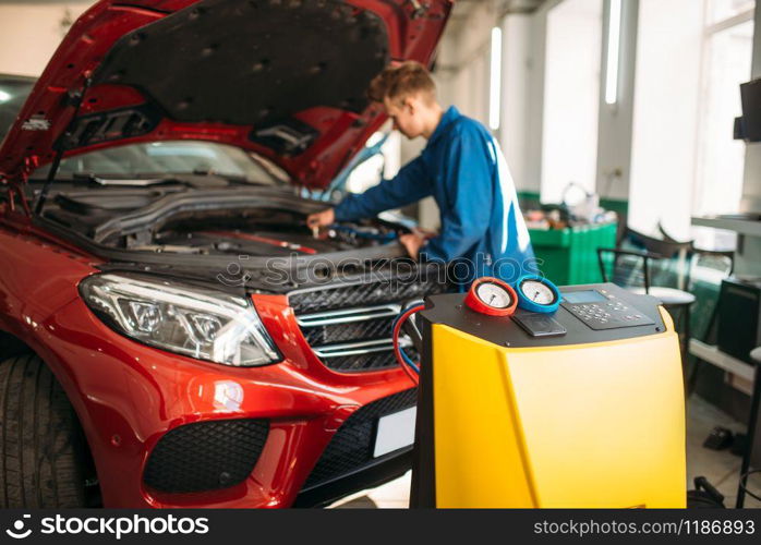 Mechanic connects air conditioning system for diagnosis of freon. Conditioner diagnostic
