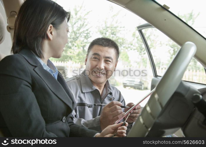 Mechanic Explaining to Businesswoman