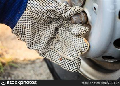 Mechanic fixing, man wearing gloves changing and repair old car tire wheel rim.. Fixing car tire with rim