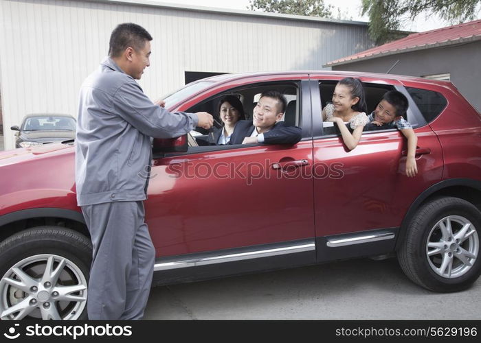 Mechanic Giving Car Keys to Family