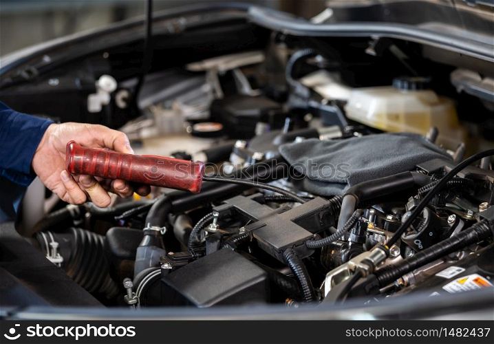 mechanic hand using Tachometer checking engine of a car