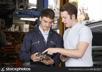 Mechanic Helping Apprentice To Fix Engine