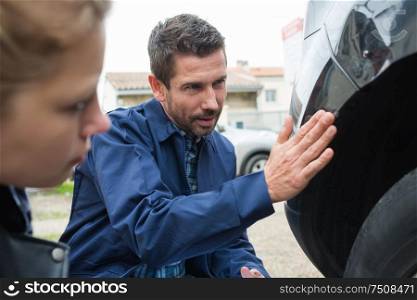 mechanic inspecting car bump