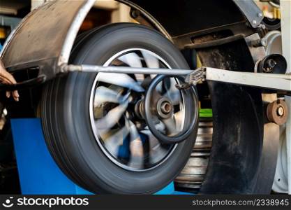 mechanic man balancing a car wheel on an automated machine