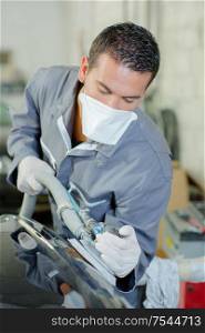 Mechanic polishing a car frame