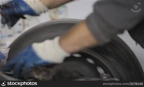 Mechanic precision spin balance and installs a new tire on a car wheel rim