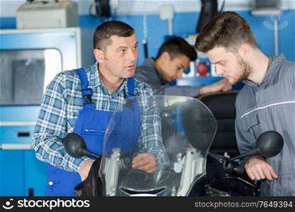 mechanic repairing a motorcycle in a workshop