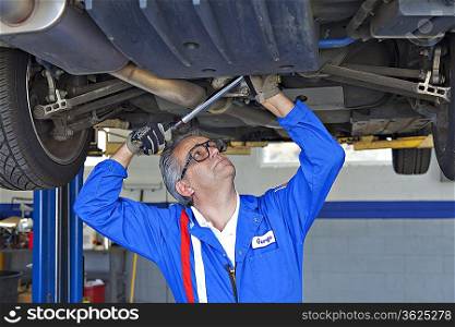 Mechanic repairing the car with a monkey wrench