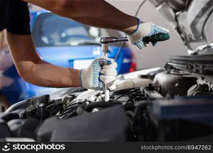 Mechanic working in auto repair garage. Car maintenance.. Mechanic working in auto repair garage. Car maintenance