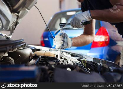 Mechanic working in auto repair garage. Car maintenance. Mechanic working in auto repair garage. Car maintenance.
