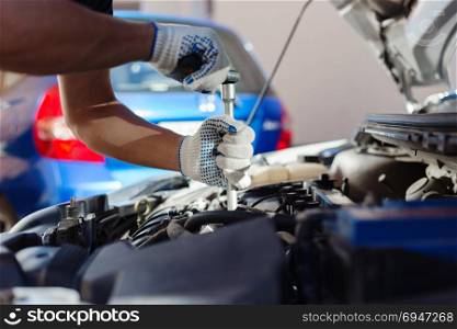 Mechanic working in auto repair garage. Car maintenance.. Mechanic working in auto repair garage. Car maintenance