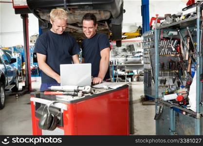 Mechanics working on laptop in auto repair shop