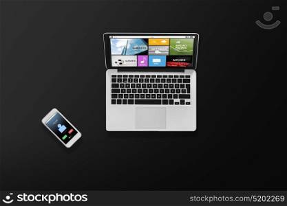 media and technology concept - laptop computer with media and smartphone top view. laptop computer with media and smartphone top view
