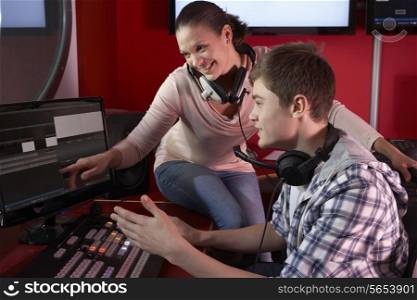 Media Student With Tutor Working In Film Editing Class