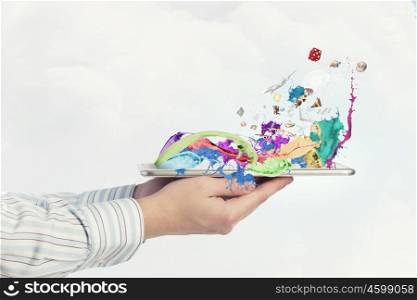 Media technologies. Close up of hand holding tablet pc with colorful splashes