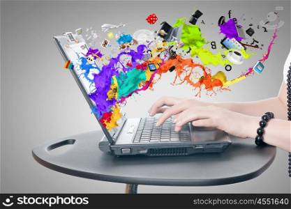 Media technologies. Hands of woman using laptop and colorful splashes on screen