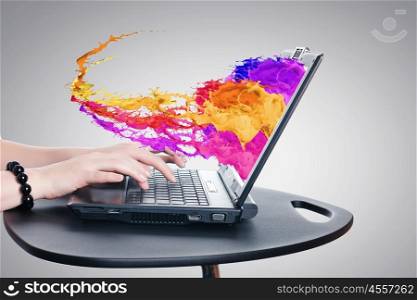 Media technologies. Hands of woman using laptop and colorful splashes on screen
