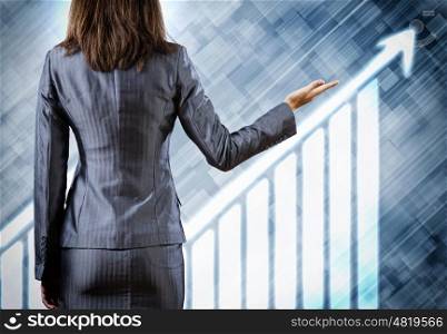Media technologies. Rear view of businesswoman and media graphs at background