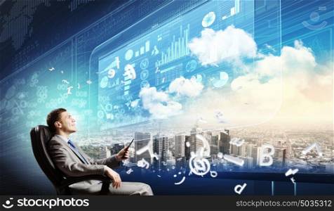 Media technologies. Young businessman sitting in chair behind media screen