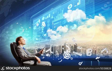 Media technologies. Young businessman sitting in chair behind media screen