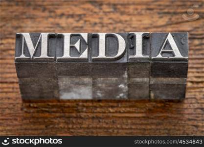 media word in mixed vintage metal type printing blocks over grunge wood