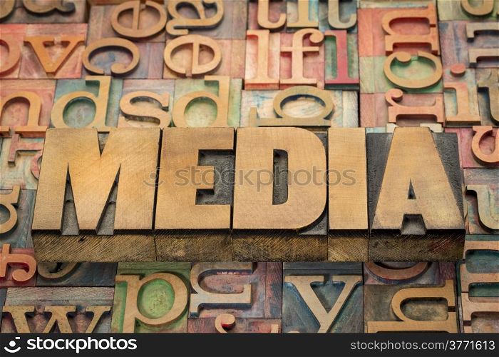 media word in wood type against background of letterpress printing blocks