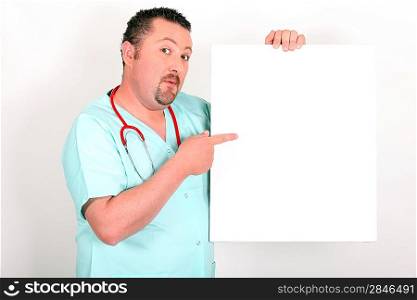 Medic in scrubs pointing at a board left blank for your image