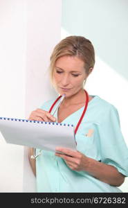 Medic wearing stethoscope examining patient&rsquo;s chart