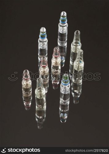 medical ampoules for injections on a dark background with reflection. capsules tablets on the mirror surface