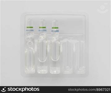 Medical ampoules of liquid for injection in plastic containers on a white background. The view from the top. tablets on a light background
