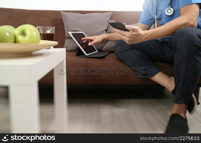 Medical and Health context,doctor hand working with smart phone,digital tablet computer,stethoscope,sitting on sofa in living room