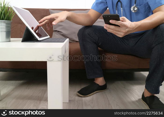 Medical and Health context,doctor hand working with smart phone,digital tablet computer,stethoscope,sitting on sofa in living room