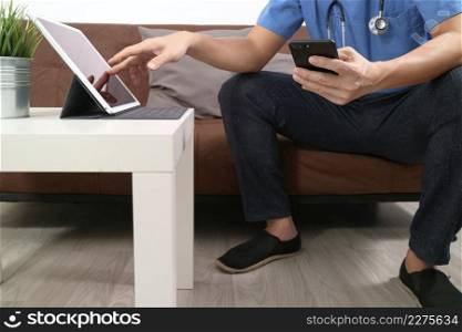 Medical and Health context,doctor hand working with smart phone,digital tablet computer,stethoscope,sitting on sofa in living room