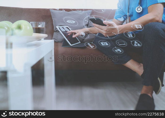 Medical and Health context,doctor hand working with smart phone,digital tablet computer,stethoscope,sitting on sofa in living room,virtual graphic interface icons screen