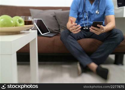 Medical and Health context,doctor hand working with smart phone,digital tablet computer,stethoscope,sitting on sofa in living room
