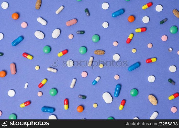 Medical background. Pattern made from Various small Pills on bright violet background. Flat lay, top view. Medical background. Pattern made from Various small Pills on bright violet background. Flat lay, top view.