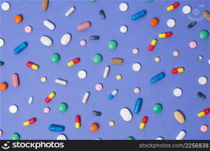 Medical background. Pattern made from Various small Pills on bright violet background. Flat lay, top view. Medical background. Pattern made from Various small Pills on bright violet background. Flat lay, top view.