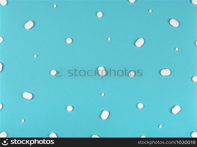 Medical background. White Pills pattern on blue background. Flat lay.. Medical background. Pills pattern on blue background