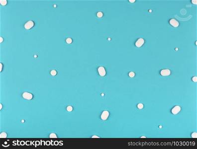 Medical background. White Pills pattern on blue background. Flat lay.. Medical background. Pills pattern on blue background